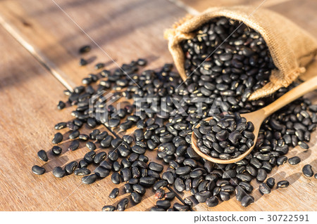 图库照片: black bean in small brown sack on wooden table back