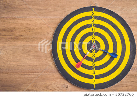 Dart arrow and dartboard on brown wooden background. Composition white free space for text or design 30722760