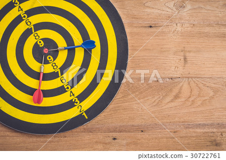 Dart arrow and dartboard on brown wooden background. Composition white free space for text or design Dart arrow and dartboard on brown wooden background. Composition white free space for text or design 30722761