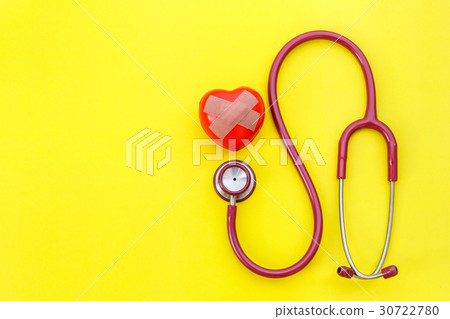 Red stethoscope and red heart shape on yellow background. For check heart or health check up concept 30722780