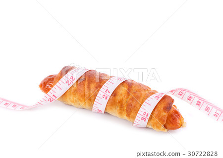Sausage bread and measurement tape. Studio shot isolated on white. Junk food, obesity or food healthy concept 30722828