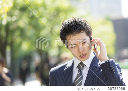 Businessman who speaks with smartphones trouble Spring Marunouchi green background 30722966