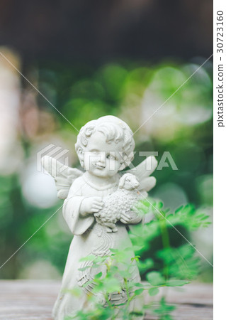 Cupid sculpture in garden,background is bokeh. Cupid sculpture in garden,background is bokeh. 30723160