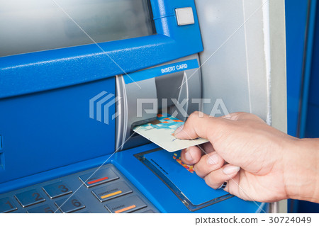 Man using ATM machine with his credit card 30724049