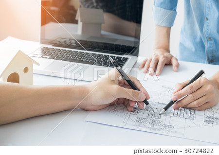 Architects engineer discussing at the table with blueprint - Clo 30724822