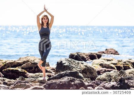 Young woman doing yoga in the beach 30725409