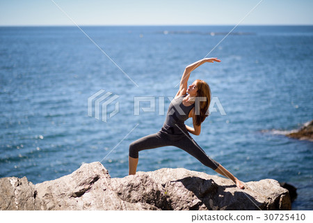 Young woman doing yoga in the beach 30725410
