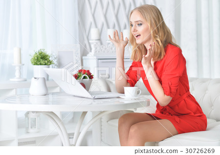 Woman working with laptop sitting at the table 30726269