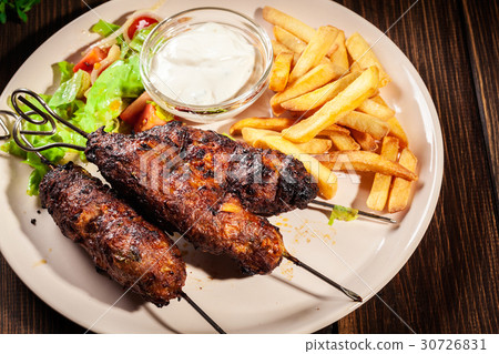 Grilled shish kebab served with fried chips Grilled shish kebab served with fried chips 30726831
