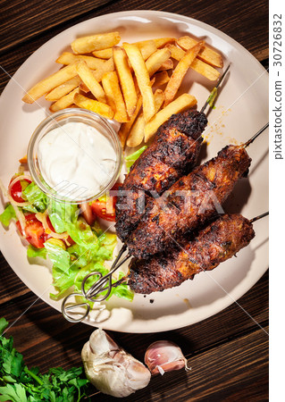 Grilled shish kebab served with fried chips Grilled shish kebab served with fried chips 30726832