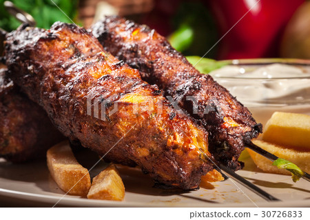 Grilled shish kebab served with fried chips 30726833