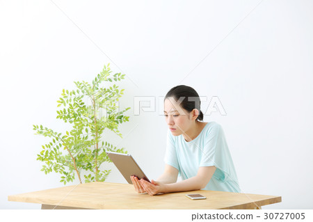 一個女人看著一台平板電腦 30727005