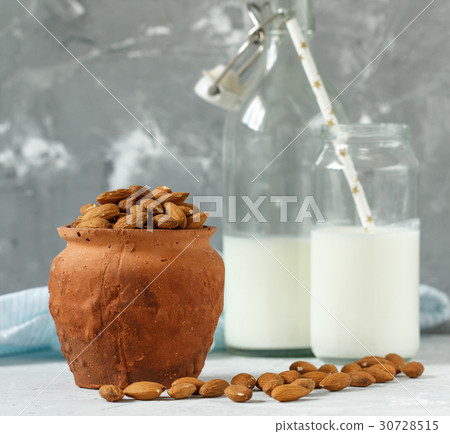 Almond milk in bottles and a pot of almonds 30728515