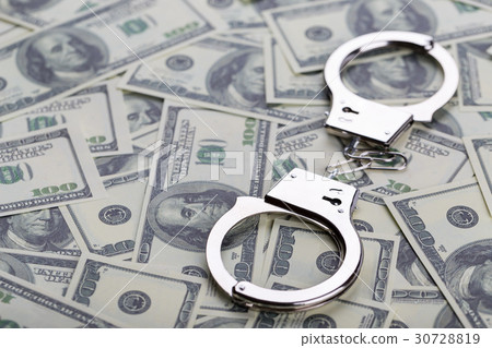 Pair of handcuffs closeup on dollar banknotes 30728819