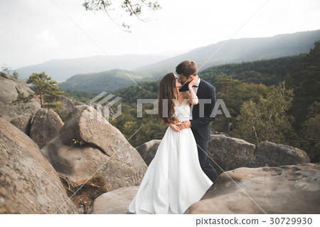Gorgeous bride, groom kissing and hugging near the 30729930