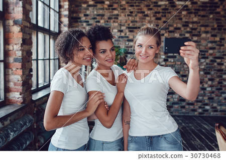 Three attractive girls in white T-shirts make 30730468