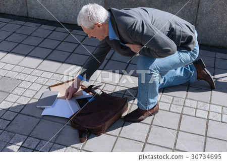 Awkward pensioner dropping bag from his hand Awkward pensioner dropping bag from his hand 30734695