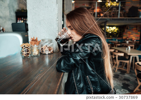 Beautiful girl in a black jacket in a cafe Beautiful girl in a black jacket in a cafe 30737869