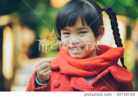 Cute young girl holding a leaves of autumn 30739789