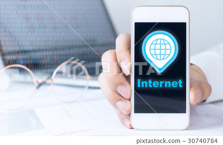 holding a phone connected to the Internet holding a phone connected to the Internet 30740784