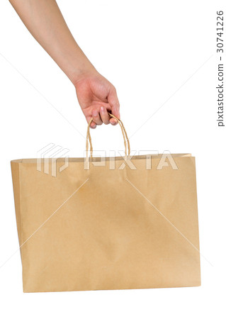Hand holding a blank brown shopping bag. 30741226