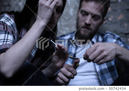 Depressed addicts heating drug over the flame Depressed addicts heating drug over the flame 30742434
