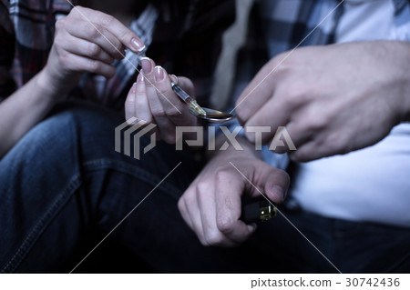 Young freaks heating drugs over the flame in the 30742436