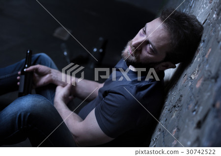 Sad alcoholic expressing desperation indoors Sad alcoholic expressing desperation indoors 30742522