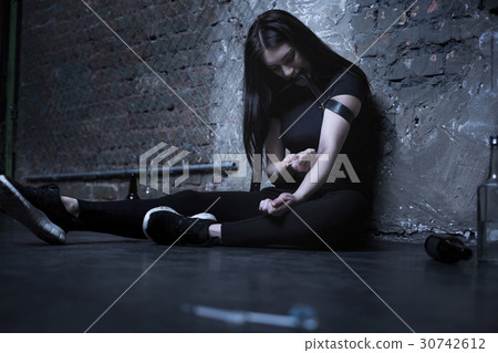 Dope obsessed woman sitting with syringe in action Dope obsessed woman sitting with syringe in action 30742612