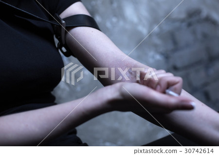 Drug addict making heroin injection outdoors Drug addict making heroin injection outdoors 30742614