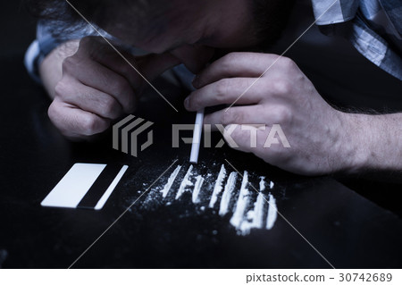 Involved drug addict inhaling cocaine lines in the Involved drug addict inhaling cocaine lines in the 30742689