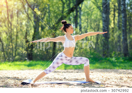 Young woman doing yoga exercises in the summer Young woman doing yoga exercises in the summer 30742992