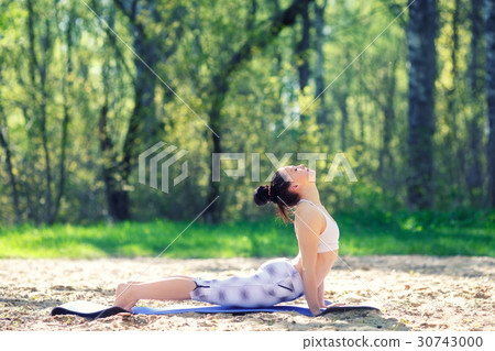 Young woman doing yoga exercises in the summer 30743000