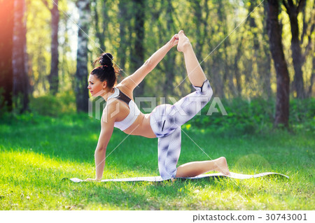 Young woman doing yoga exercises in the summer 30743001