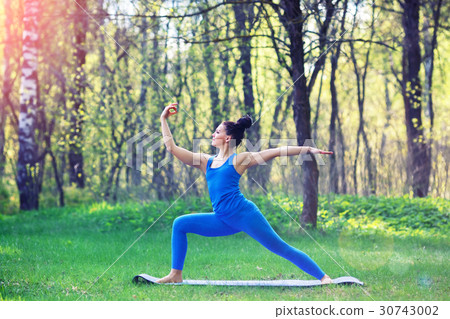 Young woman doing yoga exercises in the summer 30743002