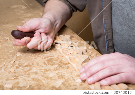 woodcarver creates a furniture ornament. woodcarver creates a furniture ornament. 30743013
