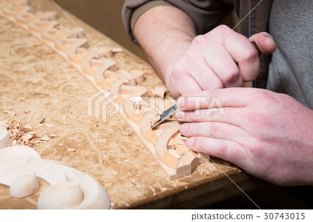woodcarver creates a furniture ornament.  30743015