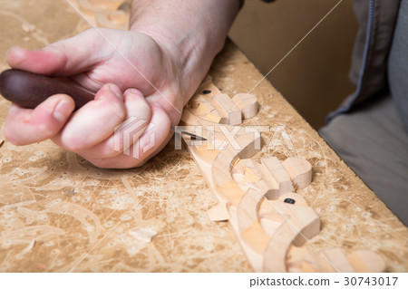 woodcarver creates a furniture ornament.  30743017
