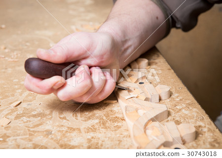 woodcarver creates a furniture ornament.  30743018