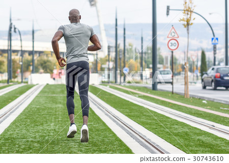 Attractive black man running in urban background Attractive black man running in urban background 30743610