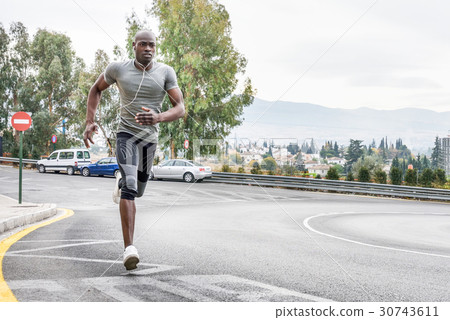 Black man running outdoors in urban road. Black man running outdoors in urban road. 30743611