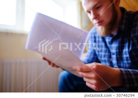 man holding paper and talking on the mobile phone  30746294