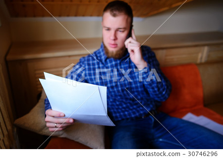 man holding paper and talking on the mobile phone  30746296