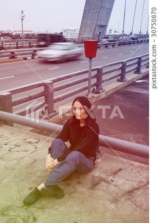 Asian ethnicity girl is on a bridge shoot. 30750870