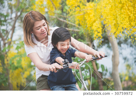 Asian mother and son riding bicycle Asian mother and son riding bicycle 30759972
