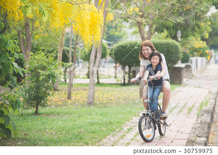 Asian mother and son riding bicycle Asian mother and son riding bicycle 30759975