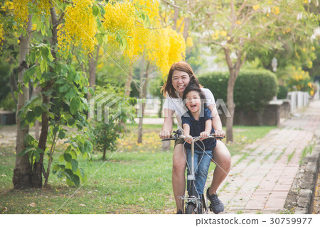 Asian mother and son riding bicycle Asian mother and son riding bicycle 30759977