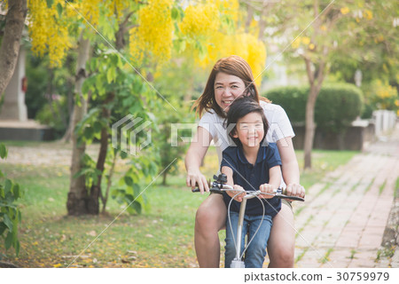 Asian mother and son riding bicycle Asian mother and son riding bicycle 30759979