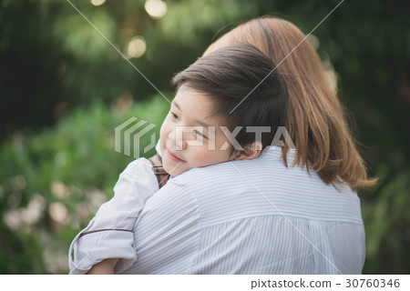 asian mother hugging with her son in the park 30760346