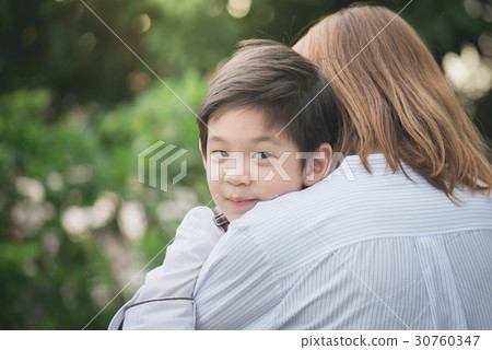 asian mother hugging with her son in the park 30760347